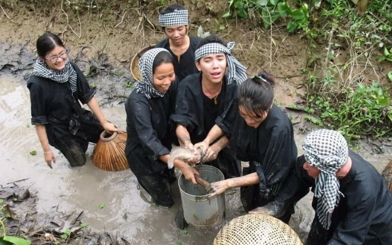 Du khách hào hứng mặc áo bà ba, quấn khăn rằn lội bùn trải nghiệm tát mương bắt cá lóc đậm chất Nam Bộ
