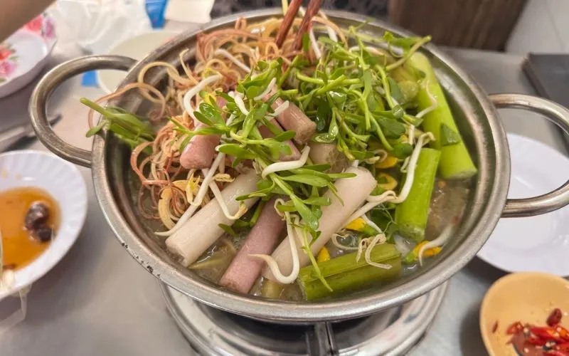 Nồi lẩu mắm miền Tây đầy ắp bông súng, bông điên điển và các loại rau đồng đặc trưng tại quán Bảy Bồng